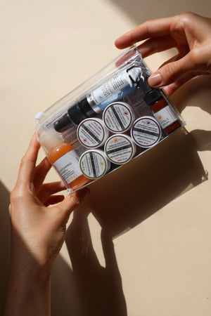Hands holding an anti-aging skincare kit in sunlight.
