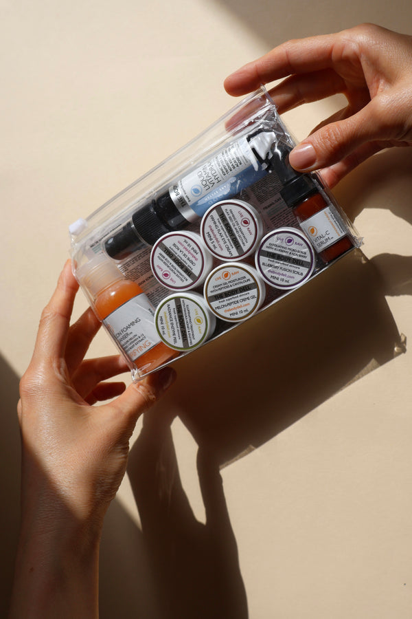 Hands holding an anti-aging skincare kit in sunlight.